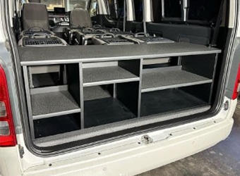 ハイエース荷室のオーダーメイド収納棚。黒い多段式の棚でキャンプ用品などを整理できる