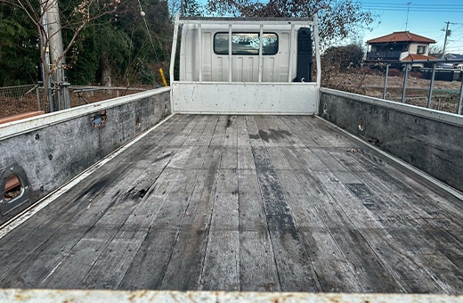 トラック荷台の床板張替え前。長年の使用で劣化し、汚れやひび割れが目立つ木製床板の状態